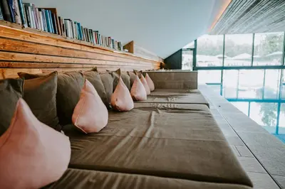 a row of pillows on a couch in a library at Hotel Petrus in Brunico