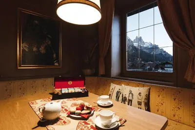 a dining room with a table with a tea set at Hotel Savoia dal 1924 in San Martino di Castrozza