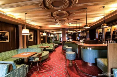 a restaurant with couches and tables and a bar at Hotel Savoia dal 1924 in San Martino di Castrozza
