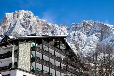 a building with a mountain in the background at Hotel Savoia dal 1924 in San Martino di Castrozza