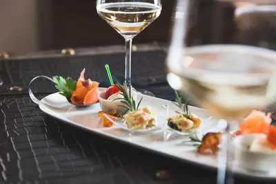a plate of food and a glass of wine at Hotel Savoia dal 1924 in San Martino di Castrozza