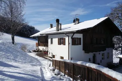 a house covered in snow with a wooden fence at Gemangerhof in Bressanone