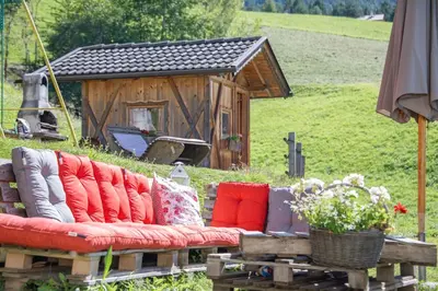 a couch with pillows sitting in front of a house at Gemangerhof in Bressanone