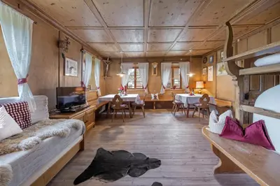 a living room with a couch and a tv and tables at Gemangerhof in Bressanone
