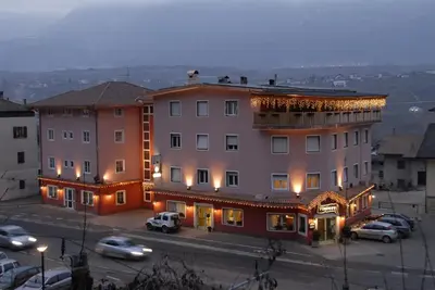 a large building with cars parked in a parking lot at Hotel Victory in Taio