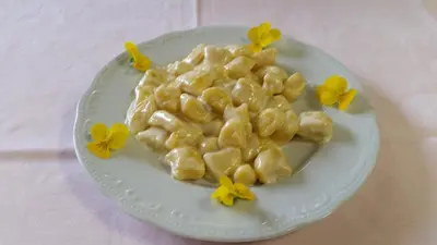 a plate of macaroni and cheese on a table at Hotel Victory in Taio
