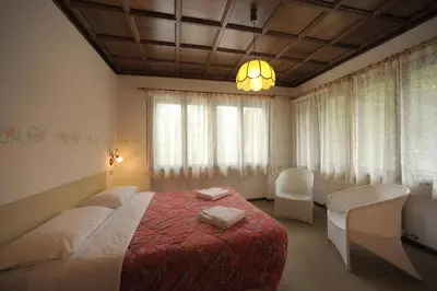 a bedroom with a bed with a red blanket at Residence Regina Delle Dolomiti in Rocca Pietore