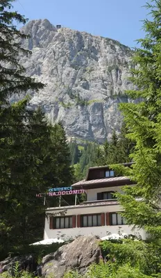 a building with a mountain in the background at Residence Regina Delle Dolomiti in Rocca Pietore