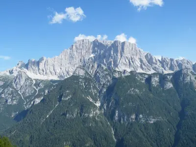 a view of a large mountain range with trees at Residence Regina Delle Dolomiti in Rocca Pietore