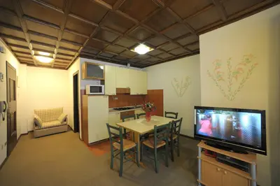 a kitchen and dining room with a table and a television at Residence Regina Delle Dolomiti in Rocca Pietore