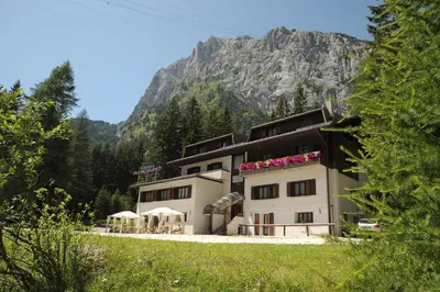 a building with a mountain in the background at Residence Regina Delle Dolomiti in Rocca Pietore