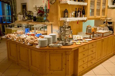 a plate of food with a sandwich and vegetables at Pineta Pastry Hotel in Rocca Pietore