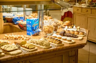 a kitchen with a counter with food on it at Pineta Pastry Hotel in Rocca Pietore