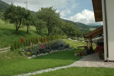 a garden with flowers in the grass next to a building at Finggeneislerhof in Villandro