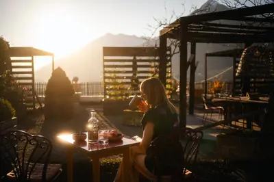 a balcony with a table and chairs and mountains at Landpalais Goyenhof - Deluxe Suites & Breakfast in Schenna