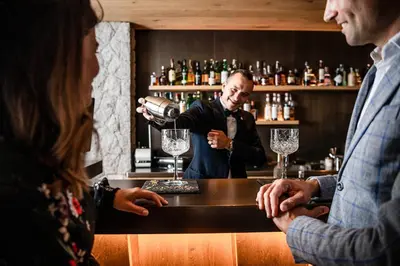 a man is pouring wine at a bar at Biancaneve Family Hotel in Selva di Val Gardena