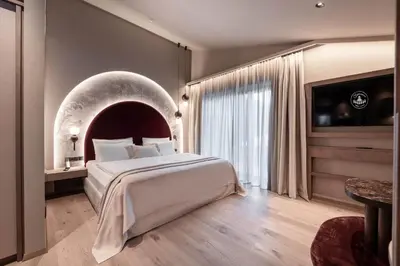 a bedroom with a large bed and a large window at Biancaneve Family Hotel in Selva di Val Gardena