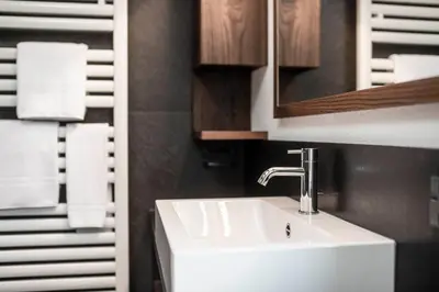 a bathroom with a white sink and a mirror at Residence Cesa Rives in Selva di Val Gardena