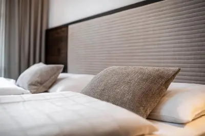 a bedroom with two beds with pillows at Residence Cesa Rives in Selva di Val Gardena