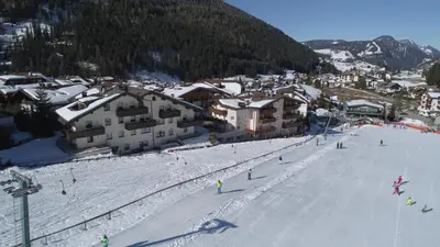 a group of people skiing down a snow covered slope at Residence Cesa Rives in Selva di Val Gardena