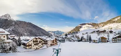 a village in the mountains covered in snow at Residence Cesa Rives in Selva di Val Gardena