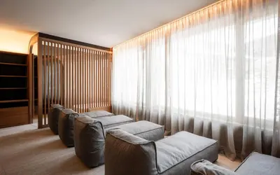 a living room with four couches and a large window at Residence Cesa Rives in Selva di Val Gardena