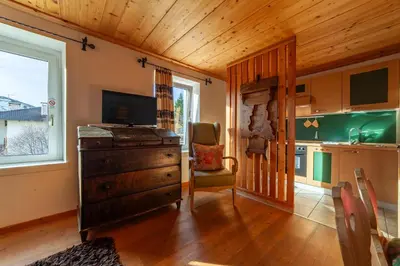 a living room with a dresser and a kitchen at Residenza Bagni & Miramonti in Cavalese