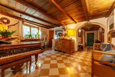 a living room with a piano and a checkered floor at Residenza Bagni & Miramonti in Cavalese