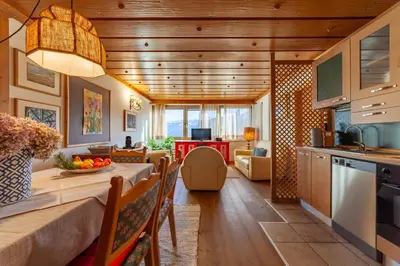 a kitchen and living room with a table and chairs at Residenza Bagni & Miramonti in Cavalese