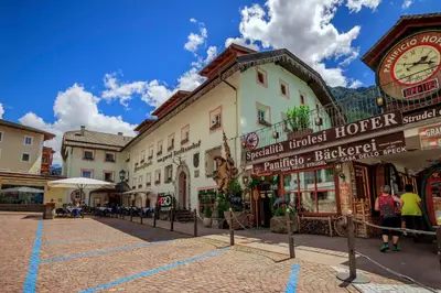a street in a town with buildings and a clock at Hotel Garni Snaltnerhof in Ortisei