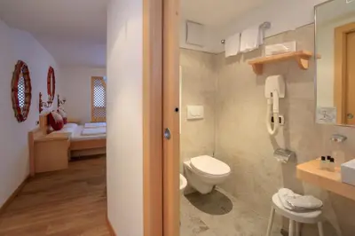 a bathroom with a toilet and a sink at Hotel Garni Snaltnerhof in Ortisei