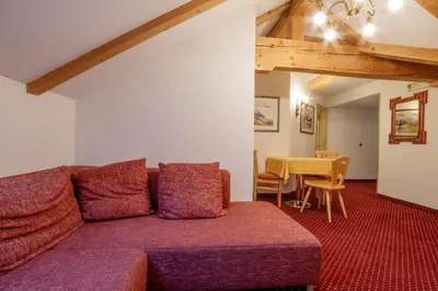 a living room with a purple couch and a table at Hotel Garni Snaltnerhof in Ortisei