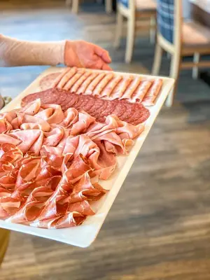 a tray of ham and other meats on a table at Garni Hotel Bel Vert in Selva di Val Gardena