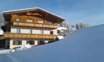 a snow covered building with a balcony on top at Posterhof in Valdaora