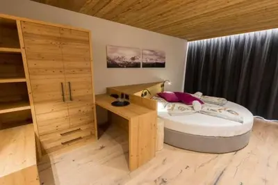 a bedroom with a bed and a desk in it at Arnica Mountain Hotel in Soraga