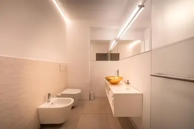 a white bathroom with a sink and a toilet at goldfinger + suites in Lana