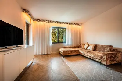 a living room with a couch and a flat screen tv at goldfinger + suites in Lana