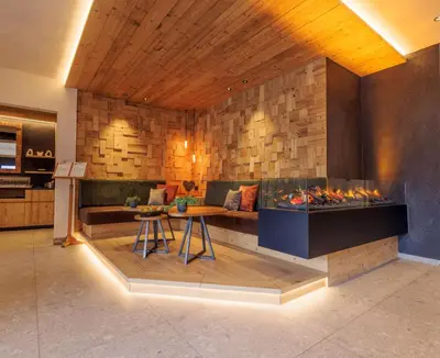 a living room with a couch and a fireplace at Geniesserhotel Messnerwirt Olang in Valdaora