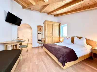 a bedroom with a bed and a desk and a television at Enjoy Dolomites - Chalet in Santa Cristina in Val Gardena