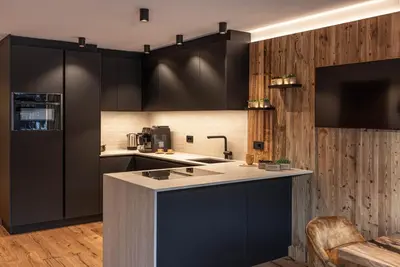 a kitchen with black cabinets and a counter top at Enjoy Dolomites - Chalet in Santa Cristina in Val Gardena