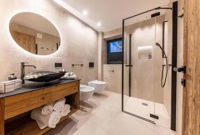 a bathroom with a glass shower and a sink at Enjoy Dolomites - Chalet in Santa Cristina in Val Gardena