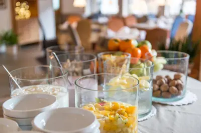 a cup on a plate on a table with spoons at Boutique Hotel Am Park in Valdaora