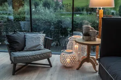 a living room with a table and chairs and a lamp at Hotel Garni Villa Park in Ortisei