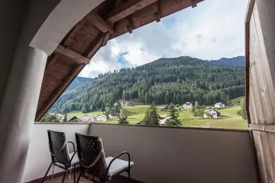 a balcony with chairs and a view of a mountain at Hotel Garni Villa Park in Ortisei