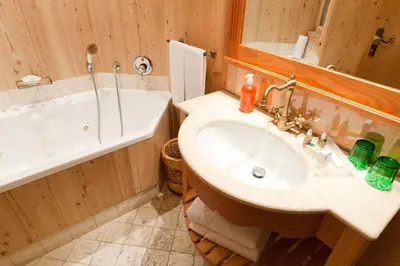 a bathroom with a sink and a bath tub at Nature Wellness Hotel Renato in Vigo di Fassa