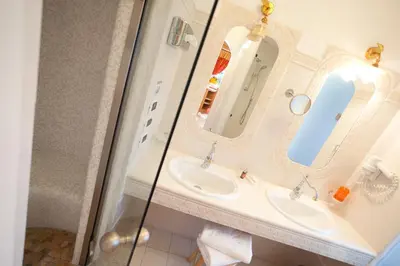 a bathroom with a sink and a mirror at Nature Wellness Hotel Renato in Vigo di Fassa