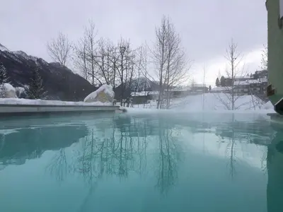 a pool of water with snow on the ground at Nature Wellness Hotel Renato in Vigo di Fassa