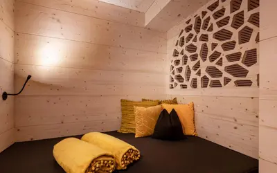 a bed in a room with wooden walls at Hotel Portillo Dolomites 1966' in Selva di Val Gardena