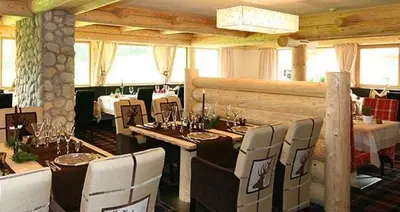 a dining room with tables and chairs in a restaurant at Hotel Portillo Dolomites 1966' in Selva di Val Gardena
