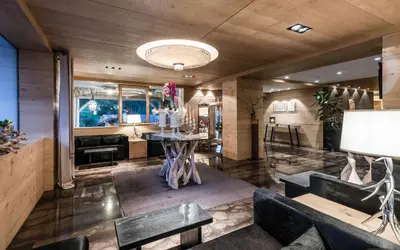 a living room with a table and a couch at Hotel Portillo Dolomites 1966' in Selva di Val Gardena